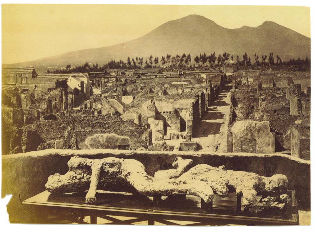 Plaster-casts of victims 2 and 3, photographed on an upper floor (possibly from VII.6.7), looking north towards Vicolo di Modesto and Vesuvius.
Centre-left can be seen the rebuilt School of Archaeology on Via Consolare. Photo courtesy of Eugene Dwyer.
