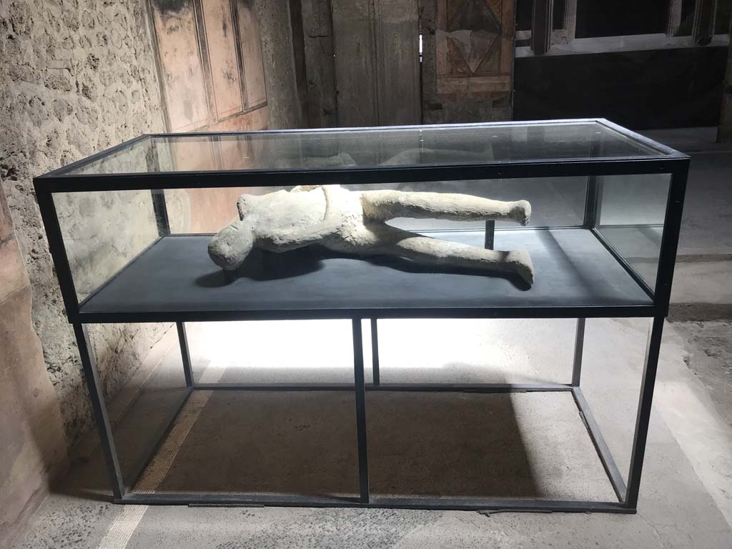 Villa of Mysteries, Pompeii. April 2019. Victim 26. Body-cast now on display in atrium. Photo courtesy of Rick Bauer.
The body of an adolescent with slender legs, gripped in the spasm of suffocation, their chest stretched out and lifted by the last gasp of breathing. 

