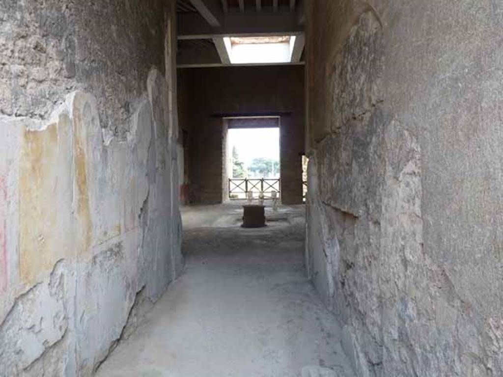 I.6.11 Pompeii. May 2010. Looking south from fauces into atrium with restored compluvium.
According to PPM, the east wall of the entrance corridor (fauces) was of III style and consisted of a geometric zoccolo (discoloured and faded). The middle area of the wall had a central aedicula with a yellow background between red side panels. The small landscape paintings (vignettes) at the centre of the panels have now disappeared.
.