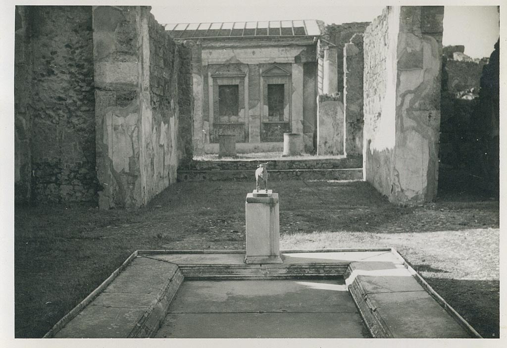 V.1.7 Pompeii. 1954. North side of impluvium in atrium with model of bronze bull, in situ. Photo courtesy of Rick Bauer.