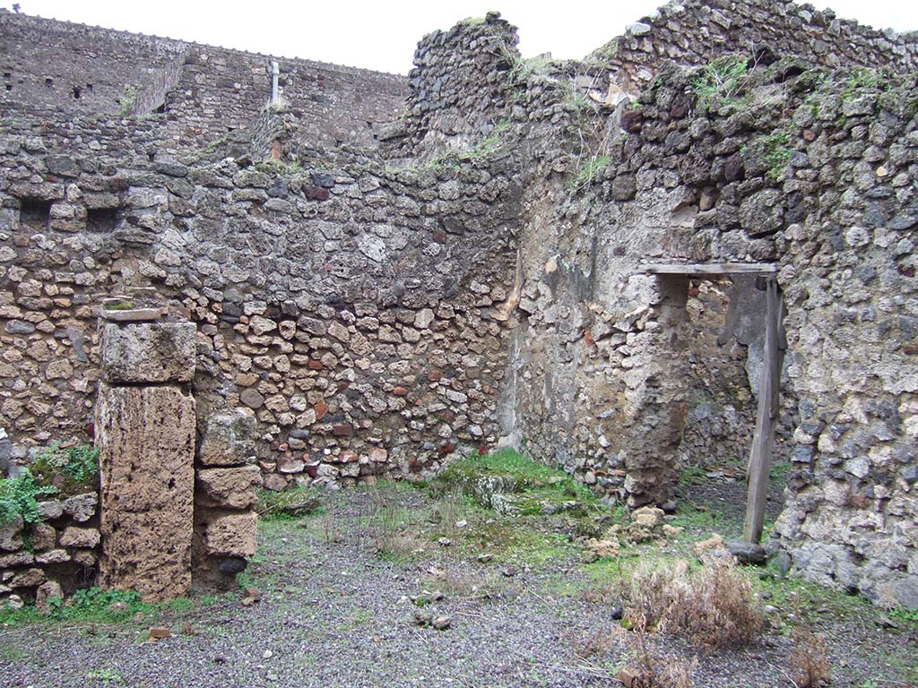 V.2.f, Pompeii. December 2005. Looking south-east across atrium. On the left would have been a cubiculum.
In the centre can be seen a room with remains of three masonry steps to an upper room above the cubiculum, and doorway to a small courtyard. 
According to NdS, on the black dado of the room with the stairs was a graffito  MID/
See Notizie degli Scavi di Antichit, 1896, (p.436).
See Mau in Bullettino dellInstituto di Corrispondenza Archeologica (DAIR), VIII, 1893, (p.7-9)
According to Jashemski, a terracotta dolium and several amphorae were found in the courtyard.
See Jashemski, W. F., 1993. The Gardens of Pompeii, Volume II: Appendices. New York: Caratzas, (p.112)
