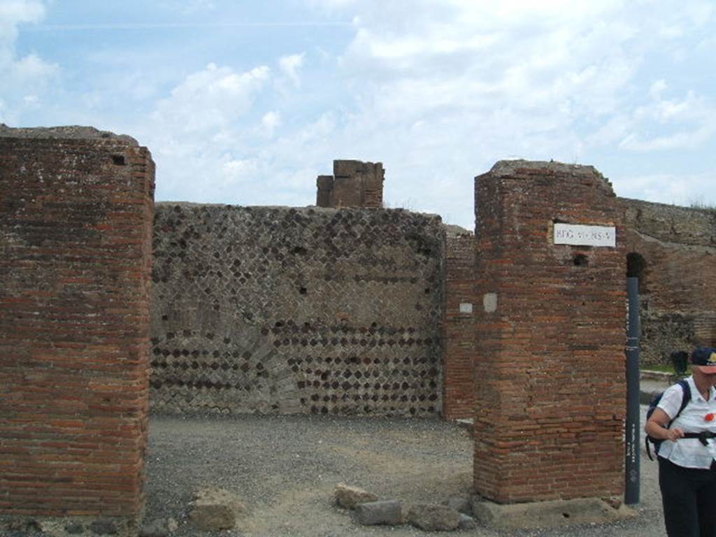 VI.6.20 Pompeii. May 2005. Looking east at entrance doorway of corner shop. According to Stefani, this was a large corner sales shop for the bakery at its rear.  On the west wall was a lararium painting with serpent, on the facing wall was a supposed cross. This bakery was called the bakery of the Christians (Panificio dei Christiani) because of the relief in stucco, now vanished. This was found on the east wall of the shop, and was wrongly interpreted as a cross, the symbol of Christianity. See Stefani, G. (2005): Pompei. Un Panificio: in Cibi e Sapori a Pompei e dintorni, (p.139) 
According to Della Corte, discovered in 1813 on the east wall in view of the road, was a panel of white stucco. On this panel in bas-relief was a Christian cross, although stylised, it was an object of veneration found opposite the pagan lararium. See Della Corte, M., 1965.  Case ed Abitanti di Pompei. Napoli: Fausto Fiorentino. (p.115)

