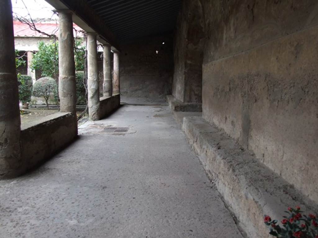 VII.5.24 Pompeii. March 2009. Looking west along north portico and stone benches (8). Midway on the right the benches turn the corner into a room said to be an oecus or exedra (9).