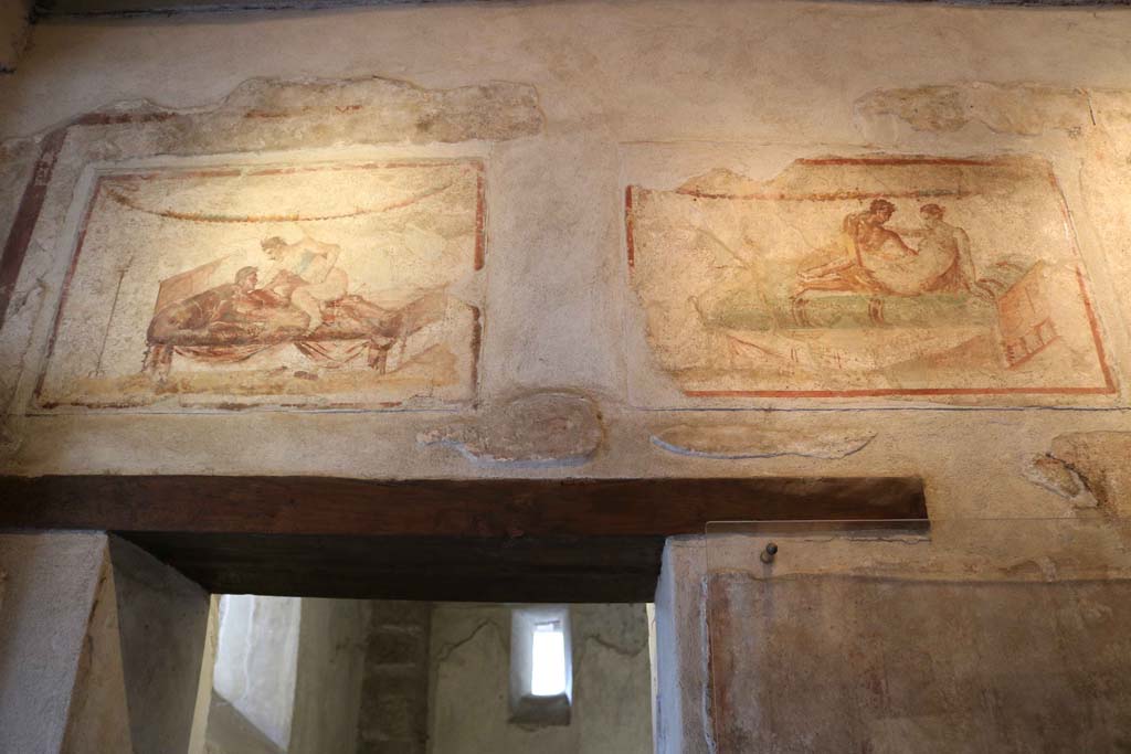 VII.12.18 Pompeii. December 2018. Painted erotic wall fresco on frieze above doorway. Photo courtesy of Aude Durand.