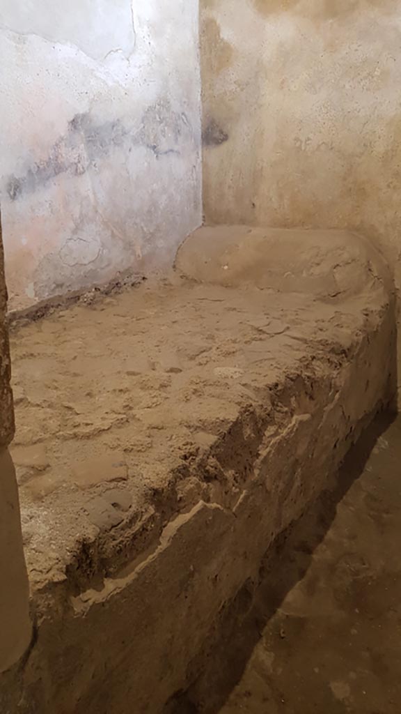VII.12.8 Pompeii. August 2023. 
Prostitutes room with stone bed. Photo courtesy of Maribel Velasco.
