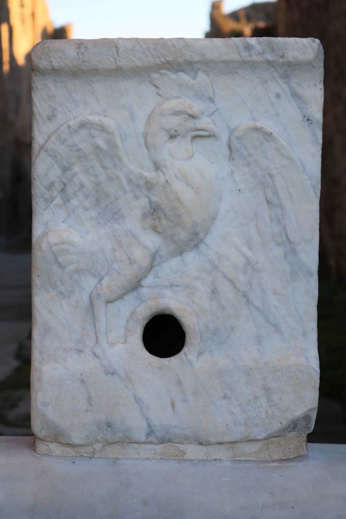 VII.15.1, Pompeii. December 2018. 
Fountain in Vicolo del Gallo showing relief of the Gallo (Cockerel). Photo courtesy of Aude Durand. 
