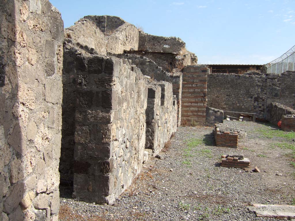 VII.7.16 Pompeii. September 2005. North side of peristyle garden, from entrance.
According to Boyce, in the north wall of the central peristyle-like room was a rectangular niche (h. uncertain, w.0.36, d.0.22, h. above floor 1.18), 
on the back wall of which was a graffito, interpreted by Fiorelli as  -
PROPI(tios)
See CIL IV 4786.
See Fiorelli, Descrizione, 247
See Boyce G. K., 1937. Corpus of the Lararia of Pompeii. Rome: MAAR 14. (p.68, no.299). 

