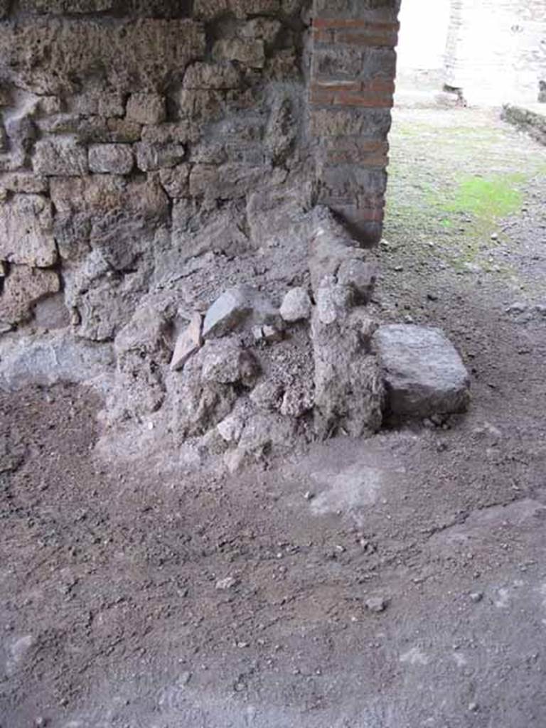 I.5.2 Pompeii. September 2010. 
Looking north towards remains of masonry podium of lararium. Photo courtesy of Drew Baker.
According to Boyce, there was a ruined lararium in a room on the north-east side of the peristyle.
It was a solid podium (0.80 by 1.0, h. varies from 0.48 to 0.90) standing against the wall, with its three sides painted in imitation marble veneer.
There was a painted aedicula on the wall above it.
He quotes – Bull. Inst., 1874, 275; Fiorelli, Descr., 451.
See Boyce G. K., 1937. Corpus of the Lararia of Pompeii. Rome: MAAR 14. (p.25 no.33).


