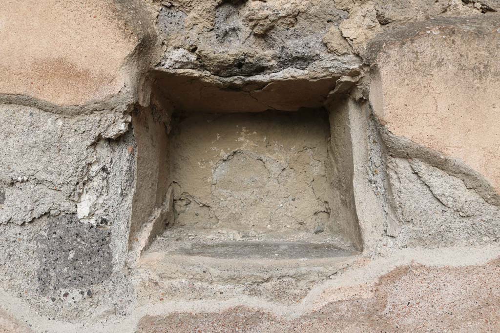 VII.1.11 Pompeii, December 2018. Niche/recess in north wall. Photo courtesy of Aude Durand.
According to Boyce – 
In the north wall is a square niche (0.28 square, d.0.24, h. above the floor 1.20), the walls of the niche were coated with the same white stucco which covered the walls of the room.
See Boyce G. K., 1937. Corpus of the Lararia of Pompeii. Rome: MAAR 14. (p.60, no.233).
