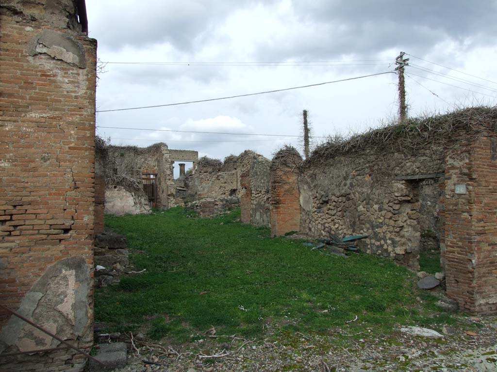 VII.4.26 Pompeii. December 2007. Shop entrance to workshop/dwelling. 
According to Fiorelli, the atrium with an impluvium would have been at the rear of the shop-room, on whose right side would have been positioned the ala, the storeroom containing the stairs to the upper rooms, and the cubiculum decorated with gladiatorial scenes.
At the rear, there was a small room bordered by the corridor, as well as a triclinium with entrance from the same corridor, which in its length gave access to three other rooms, a small garden and the kitchen, which had a separate latrine, and in the wall against the hearth showed a painting with Hercules before the altar, assisted by the Tibicine between the two Lares: in the lower part of the painting were two men with an amphora, and other amphorae on a cart. On the side wall, were the painted serpents and table. 
See Pappalardo, U., 2001. La Descrizione di Pompei per Giuseppe Fiorelli (1875). Napoli: Massa Editore. (p.90).
