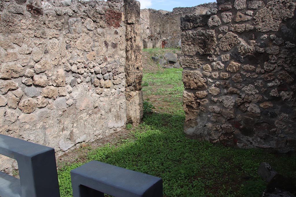 I.2.2 Pompeii. October 2024. 
Looking towards north wall of shop-room, with doorway to atrium of I.2.3 in east wall at north end. Photo courtesy of Klaus Heese.
