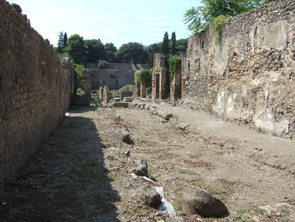 I.5 Pompeii. September 2005. Vicolo del Conciapelle looking west .      Wall of I.2.24.