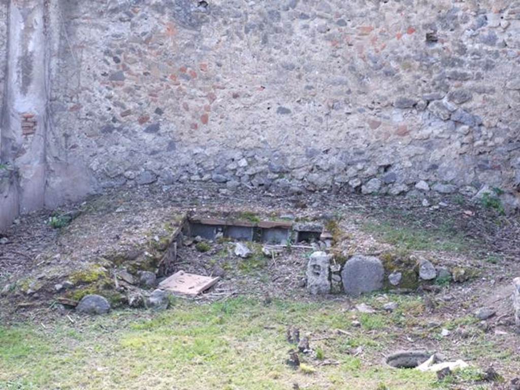 I.2.28 Pompeii. March 2009. Looking west towards garden triclinium.  
Each couch had four niches on its inside wall.   The four from the couch against the west wall are visible here. Taken from I.2.20. A second cistern-mouth can be seen on the right of the photo.

