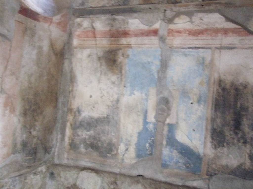 I.7.19 Pompeii. December 2006. East wall of cubiculum on north side of corridor. According to PPM, the east side of the room was reserved for the bed, as indicated by the bed recess in the wall. The alcove was brightened, also, by a circular splayed window which gave light from the small courtyard. The only one of the three painting still legible was that on a black background showing Helen and Paris, which was in the middle of a large pink panel. The corner panels were black.
