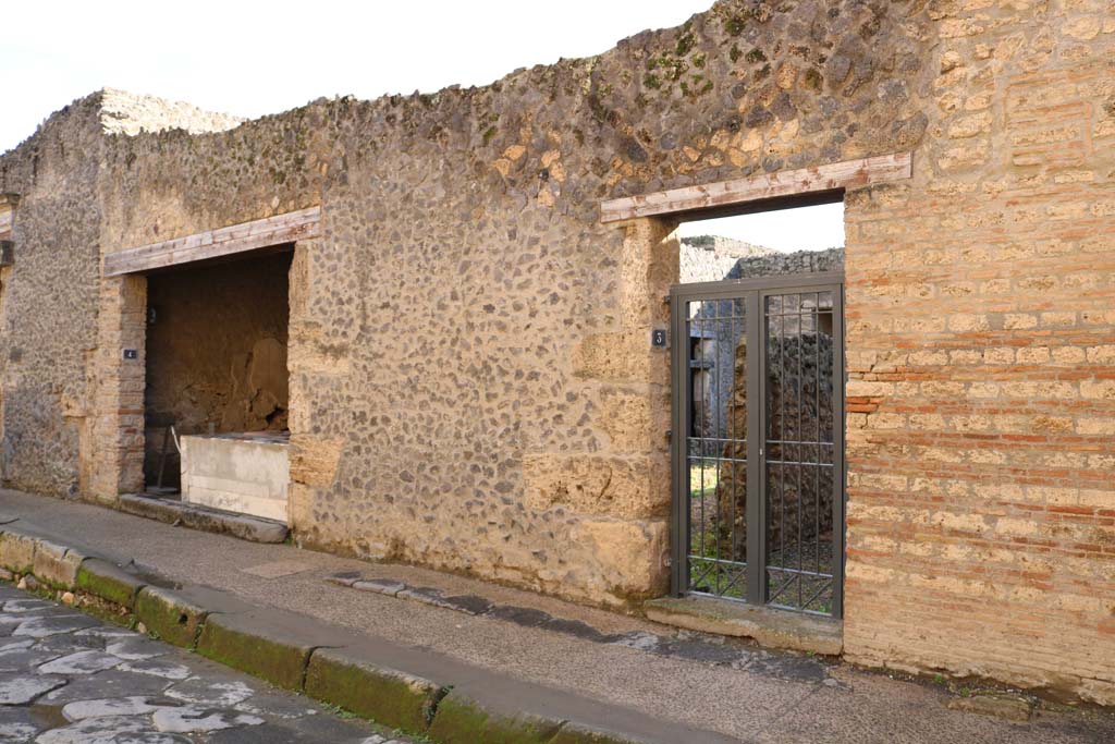 I.9.3 Pompeii, on right, and I.9.4, on left. December 2018. 
Entrance doorways on south side of Via dellAbbondanza. Photo courtesy of Aude Durand.
