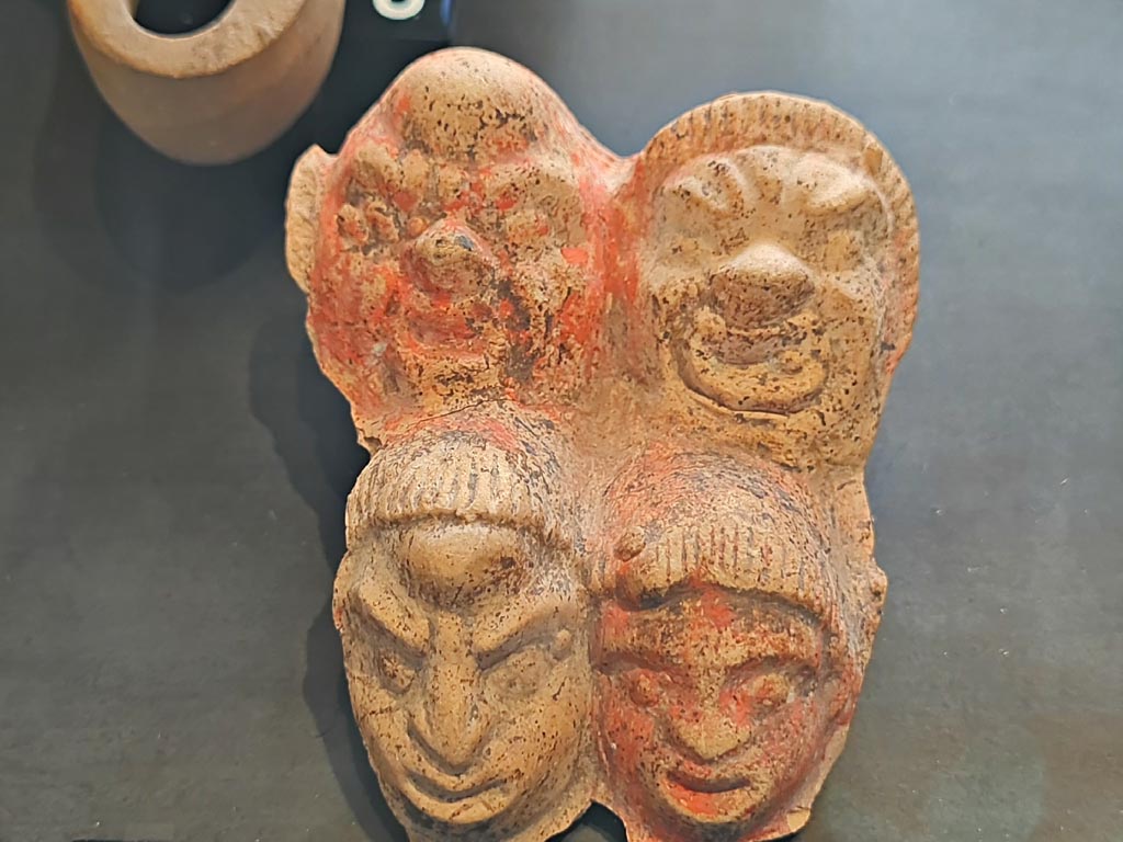 I.9.13 Pompeii. March 2024. No. 5, Plaque with theatre masks. Photo courtesy of Giuseppe Ciaramella.
On display in exhibition in Palaestra entitled – “L’altra Pompei, vite comuni all’ombra del Vesuvio”.
