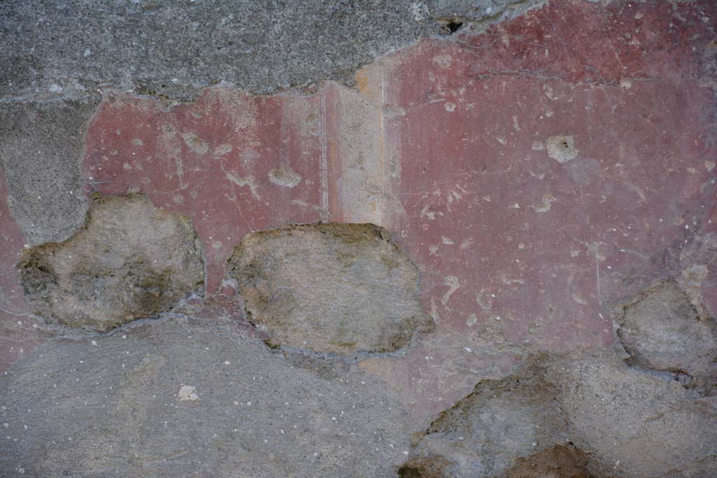 I.10.5 Pompeii. April 2017. Remaining red painted plaster on exterior wall, east of doorway. Photo courtesy Adrian Hielscher.