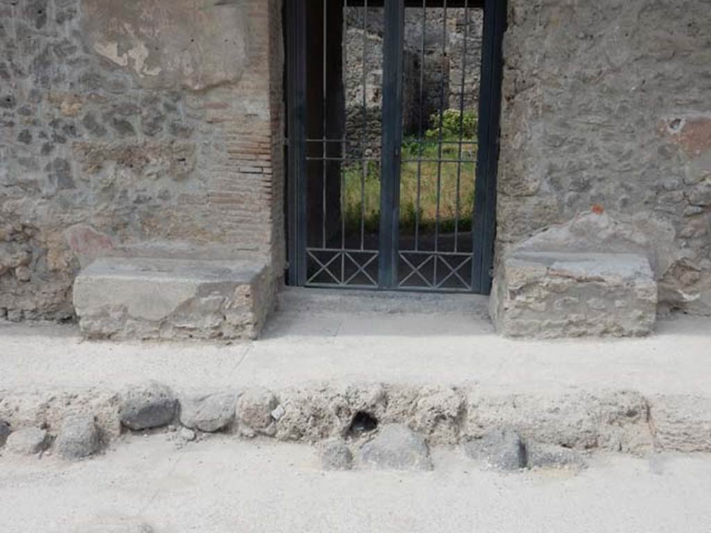 I.10.18 Pompeii. May 2017. Looking west to entrance doorway. Photo courtesy of Buzz Ferebee.
According to NdS 
The entrance to this modest house had a lava threshold framed between a brick door-jamb and one of limestone blocks, with the walls of the high zoccolo of red plaster and with a white upper part, in which stood out lively inscriptions, simple and unpretentious, on the other end of the two masonry benches that stand to the right and to the left of the entrance.
See Notizie degli Scavi di Antichit, 1934, p.341

