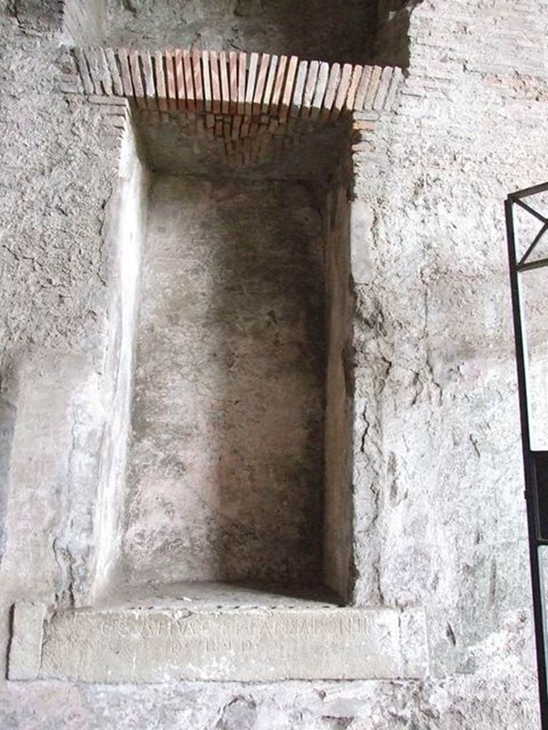 II.6 Pompeii. December 2006. Large rectangular niche, on west side of corridor in Amphitheatre.  One of two inscriptions to father and son Cuspius Pansa.  They restored the Amphitheatre at their own expense after the earthquake of AD62.

