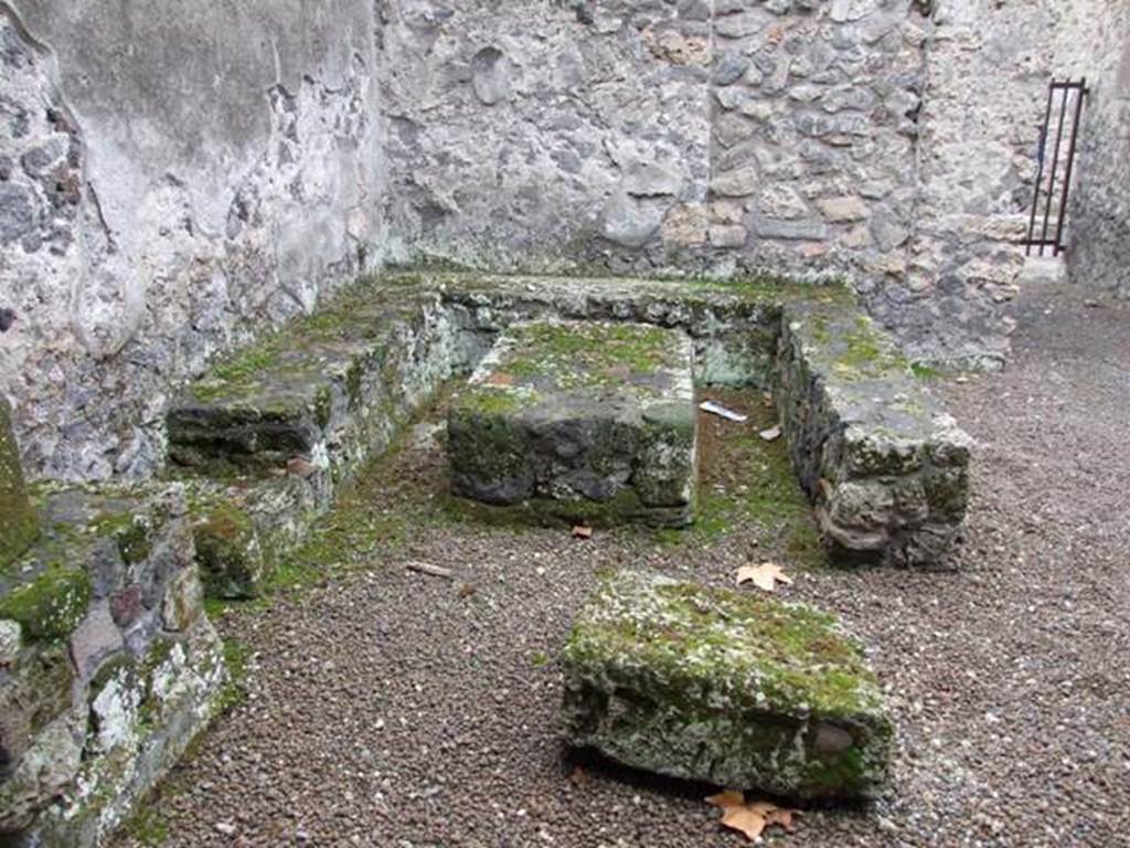 II.8.5 Officina di Sabbatino.  December 2007.  Three sided stone bench and table in south west corner of atrium area.