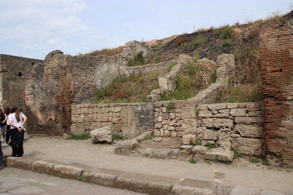 III.6.3 Pompeii, on left. May 2024. Looking north-west towards entrance to shop with doorway threshold.
In the centre, is the entrance doorway/corridor into the unexcavated Casa di M. Satrius at III.6.4, with rear west upper walls showing. 
Photo courtesy of Klaus Heese
