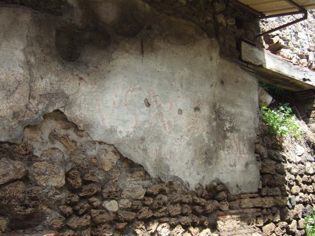 V.7.6 Pompeii. May 2006. Remains of painted graffiti on front wall, west of doorway.