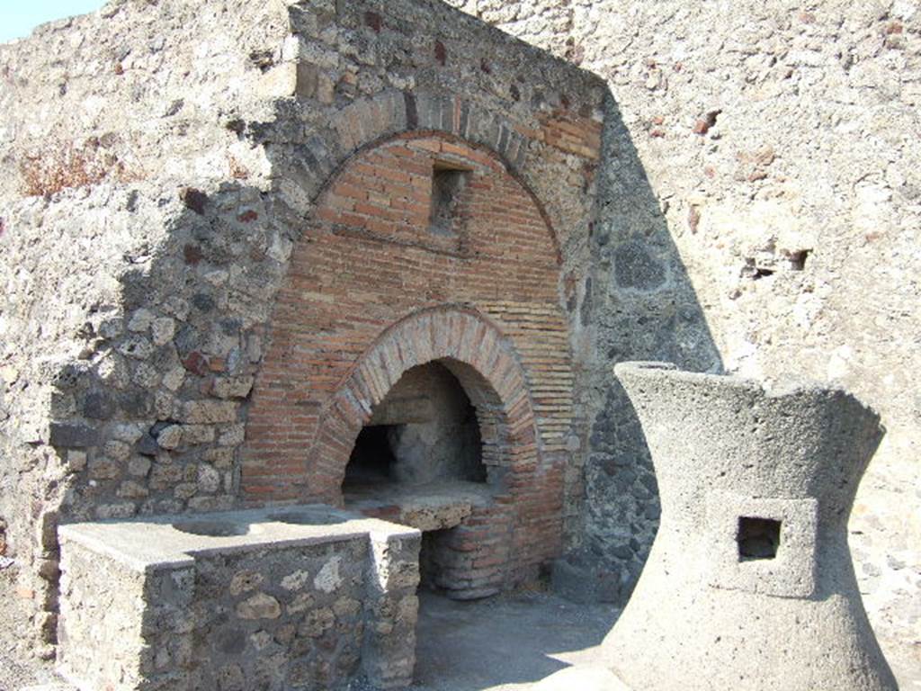VI.6.17 Pompeii. May 2006. Bench, oven, and mill in bakery.