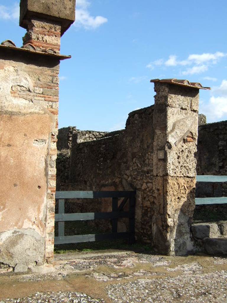 VI.10.4 Pompeii. December 2005. Entrance doorway.
According to Leach, a respectable tavern couple, Caprasia and Nymphius, supported the campaign of their down-the-street neighbours the Vettii. She said that given that Caprasias name showed a family affiliation with Vettiuss adoptive son Caprasius, the connection drew her attention to the social dynamics of the neighbourhood. See Leach, E.W: The Social Life of Painting in Ancient Rome and on the Bay of Naples.
According to Della Corte, Caprasia lived on this insula, together with Nymphius, perhaps her husband.  They ran the caupona at number 3, from the front of the dwelling at number 4. A written recommendation was found on the pilaster between 6 and 7 -  Caprasia cum Nymphio rog(at) una et vicini   [CIL IV 171] See Della Corte, M., 1965.  Case ed Abitanti di Pompei. Napoli: Fausto Fiorentino. (p.55)

According to Epigraphik-Datenbank Clauss/Slaby (See www.manfredclauss.de), this read as 

A(ulum) Vettium Firmum 
aed(ilem) o(ro) v(os) f(aciatis) dign(um) est 
una et vicini o(ro) v(os) f(aciatis)             [CIL IV 171]

According to Coarelli and Pesando, CIL IV 171 reads as 
A VETTIVM FIRMVM 
AED O V F DIGN EST 
CAPRASIA CVM NYMPHIO ROG
VNA ET VICINI O V F

See Coarelli, F. and Pesando, F. (a cura di), 2006. Rileggere Pompei, Volume 1: Linsula 10 della Regio VI. Roma: LErma di Bretschneider. (p. 106-7).
