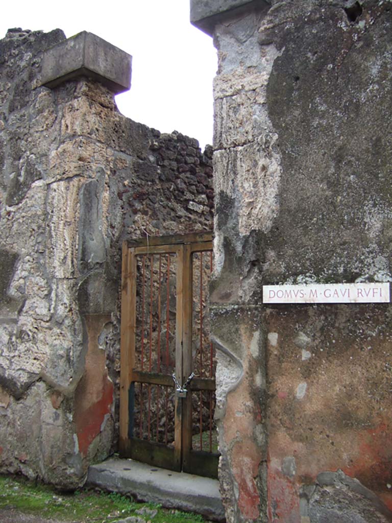 VII.2.16 Pompeii. December 2005. Entrance, with cubic tufa capitals.
Della Corte thought that the identification of the owner of this house as being M. Gavi Rufi should be rejected.
The identification was based on two inscriptions found on the red plaster at the sides of the doorway
M. GAVI. DOMVS    on the left, and
RVFII VA(le)   [CIL IV 2319f]  on the right between VII.2.16 and VII.2.17.
Therefore, he said, this house owner should remain anonymous.
Fiorelli thought these inscriptions gave the ownership of the house, without doubt, to duumvir M. Gavio Rufo.
See Della Corte, M., 1965. Case ed Abitanti di Pompei. Napoli: Fausto Fiorentino. (p.154)
See Pappalardo, U., 2001. La Descrizione di Pompei per Giuseppe Fiorelli (1875). Napoli: Massa Editore. (p.81)

Also found on the wall of the house, according to Cooley,
Marcus Vecilius Verecundus, outfitter.  [CIL IV 3130]
See Cooley, A. and M.G.L., 2004. Pompeii: A Sourcebook. London: Routledge. (p.176, H55)
According to Della Corte, the graffito was found on a column in the house:
M. Vecilius Verecundus, Vestiar(ius)      [CIL IV 3130]
See Della Corte, M., 1965. Case ed Abitanti di Pompei. Napoli: Fausto Fiorentino. (p.280)

Also found on the wall between VII.2.16 and shop at VII.2.17,
Vesbinus cinedus, Vitalio pedicavit     [CIL IV 2319b]
See Varone, A., 2002. Erotica Pompeiana: Love Inscriptions on the Walls of Pompeii, Rome: Lerma di Bretschneider. (p.137)
