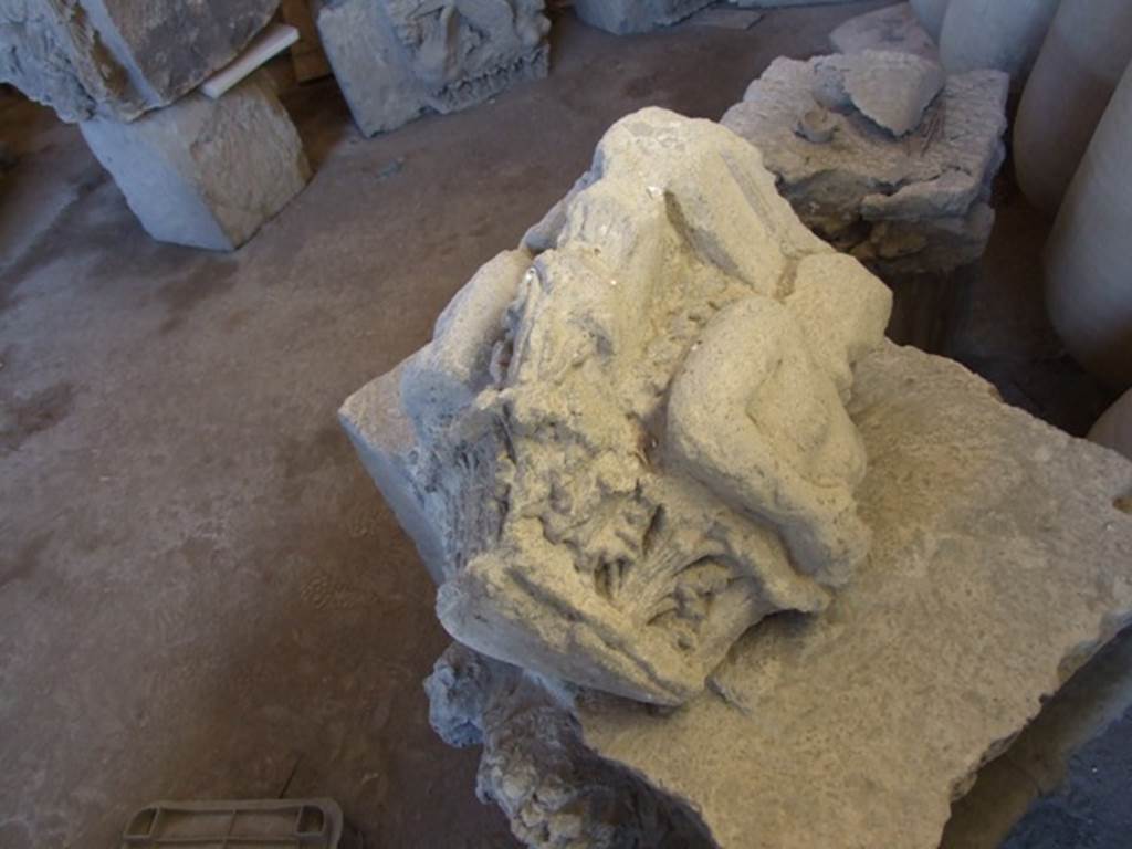VII.4.59 Pompeii. December 2006. Remains of a capital in storage in the Forum Granary store VII.7.29. This damaged capital of Nocera tufa was found lying abandoned in a room of VII.4.59. Spano suggested it may have been the capital from the right side of the entrance of the House of Ariadne. The above photo shows the side that would have been pointing onto the Via della Fortuna. See Notizie degli Scavi di Antichità, 1910, p.280 and p.282, fig. 12.