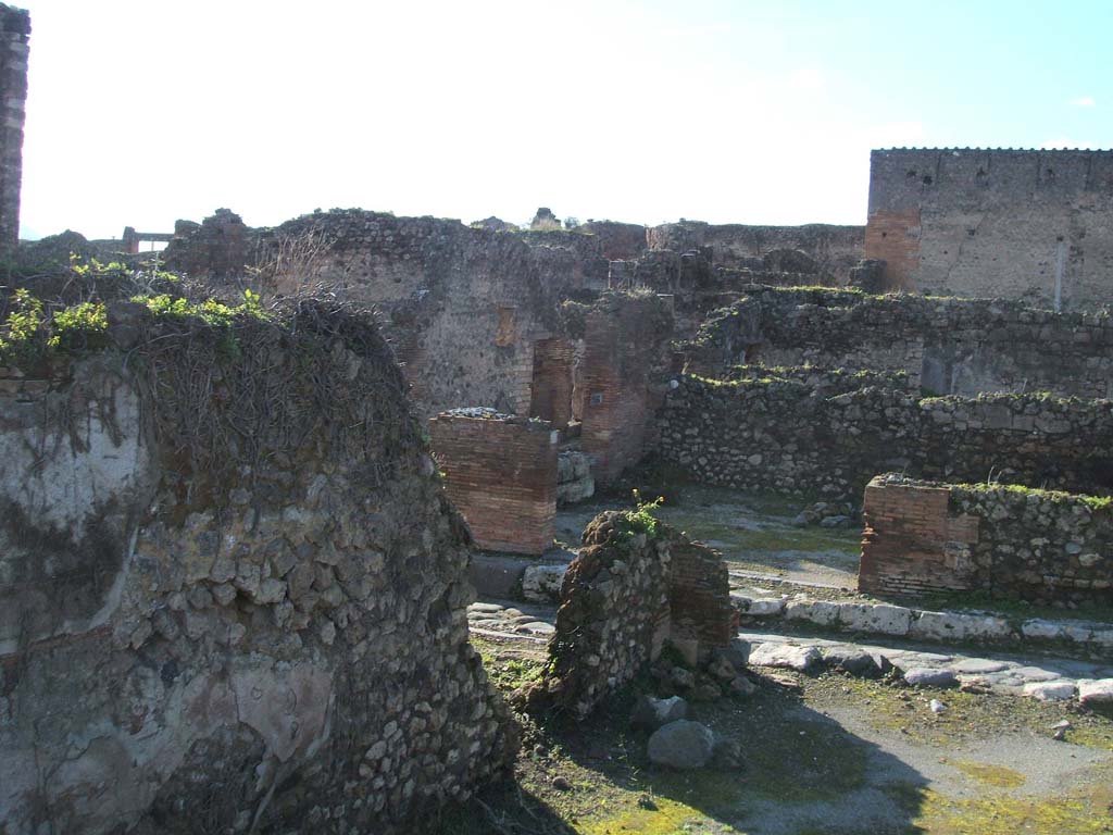 VII.12.35 Pompeii. December 2004. Looking west onto Vicolo di Eumachia. VII.12.35 in foreground with doorway to VII.12.34., in centre