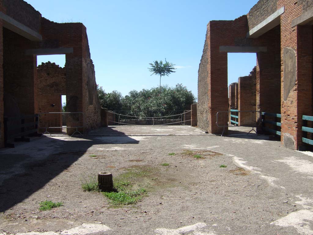 VIII.2.16 Pompeii. September 2005. Looking west across site of impluvium in atrium.
On the west side of the atrium is a doorway, on left, leading into a passageway and room onto the east portico.
The tablinum is in the centre, and the doorway to a triclinium is on the right. On both sides of the side walls is an open ala.
