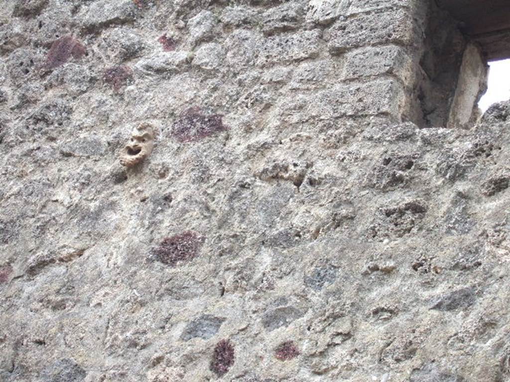 IX.5.13 Pompeii. May 2006. Face in stonework high up on front wall.