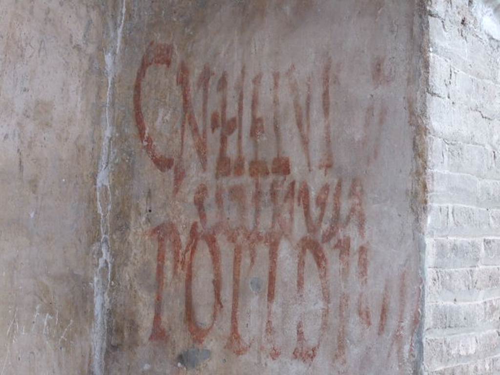 IX.7.5 Pompeii. December 2006. Graffiti outside workshop of Verecundus. According to Epigraphik-Datenbank Clauss/Slaby (See www.manfredclauss.de) CIL IV records this as two entries 
Cn(aeum)  Helvium 
Sabinum    [CIL IV 7831]

Popidium 
aed(ilem)  o(ro)  v(os)  f(aciatis)    [CIL IV 7832] 

Also see Varone, A. and Stefani, G., 2009. Titulorum Pictorum Pompeianorum, Rome: Lerma di Bretschneider. (p. 398)
