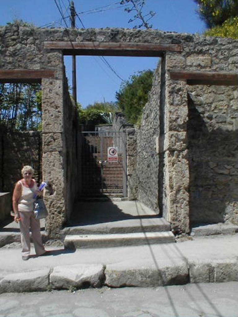 IX.7.12 Pompeii. May 2005. Wide entrance with long corridor [1].
This leads to fauces [2], which is situated where the gate is.
Modern steps lead above the buried ruins to the Casina dell’Aquila.
