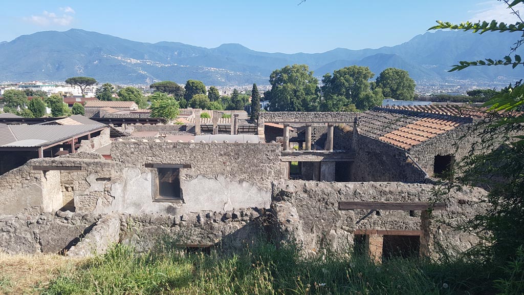 View from Casina dell’Aquila above IX.7.12, looking south towards upper floor of I.6.7, in centre. August 2023. Photo courtesy of Maribel Velasco.