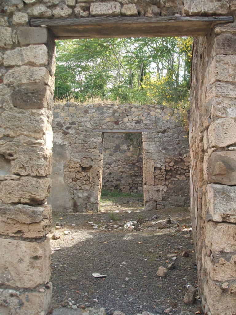 IX.7.19 Pompeii. May 2005. 
Looking east from entrance doorway into room b, the atrium with doorway to room g, triclinium, ahead.
According to Mau, this narrow atrium had an impluvium but was without a fauces, or entrance corridor.
See Mau, Bullettino dell’Instituto di Corrispondenza Archeologica (DAIR), 1883, (p.78)
