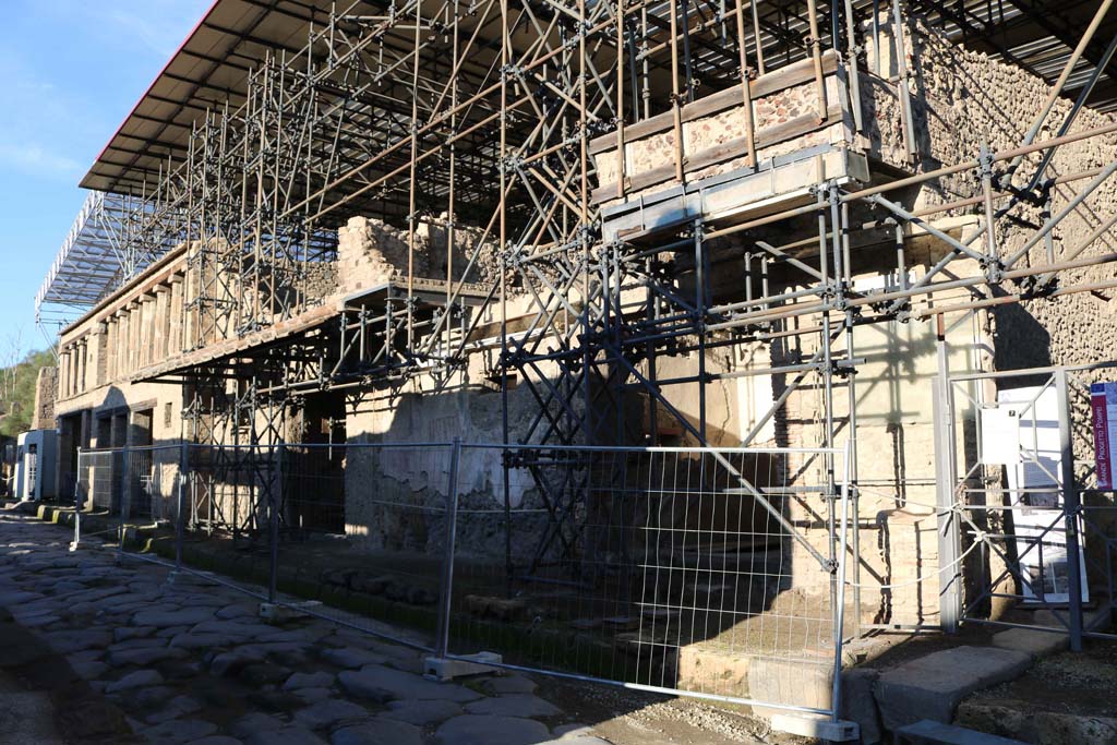 IX.12.7 Pompeii, on right. December 2018. 
Looking west along front faade, from IX.12.7 towards IX.12.1, on left. The street altar can be seen on the right. 
Photo courtesy of Aude Durand.
