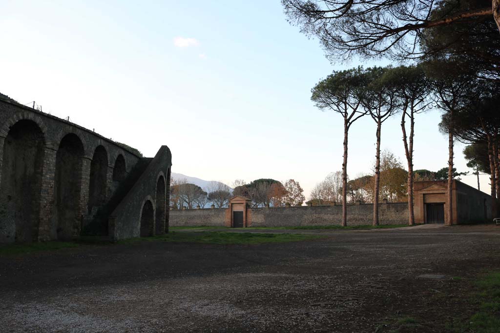 Piazzale Anfiteatro. December 2018. 
Amphitheatre, on left, looking west towards entrance to II.7.5 Grand Palestra, on right, and II.7.4, in centre. Photo courtesy of Aude Durand
