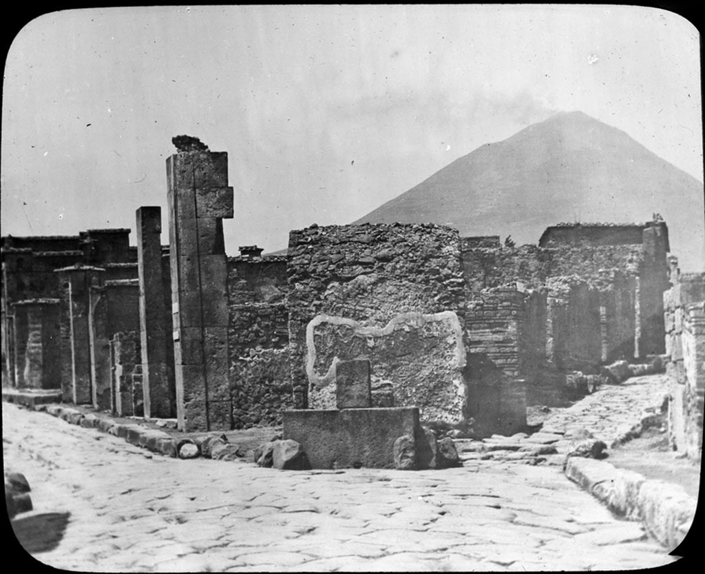 Via Consolare, on left.  Photo by York and Son. Looking north to junction with Vicolo di Narciso, on right. 
Used with the permission of the Institute of Archaeology, University of Oxford. File name instarchbx208im 010a. Source ID. 56370.
See photo on University of Oxford HEIR database
