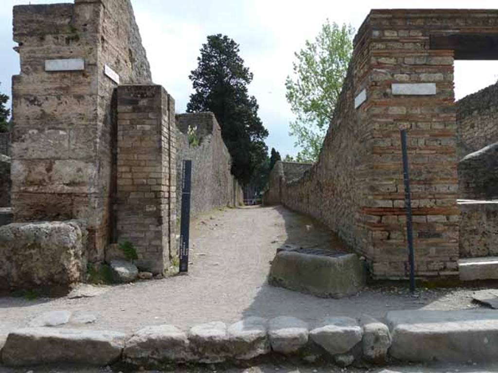 Via dell’Abbondanza, south side. May 2010. Looking south past water tower along Vicolo di Octavius Quartio, between II.2 and II.1.