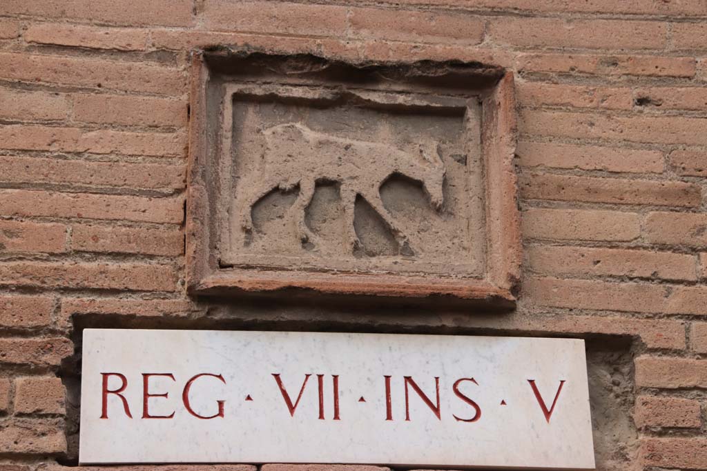 Vicolo dei Soprastanti, north side, October 2020. Terracotta plaque on west end of Insula V. Photo courtesy of Klaus Heese.
