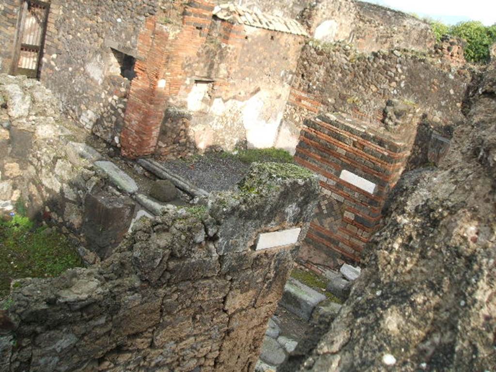 Vicolo di Eumachia (left to centre) between VII.9 and VII.10. December 2004.
Looking to north of the crossroads with Vicolo degli Scheletri. 

