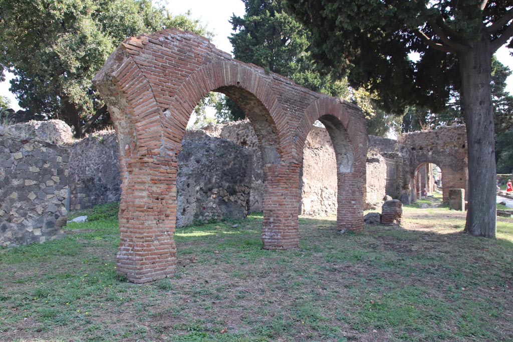 HGE18 Pompeii, on left. October 2023. Looking south-east towards portico with shops at rear. Photo courtesy of Klaus Heese.