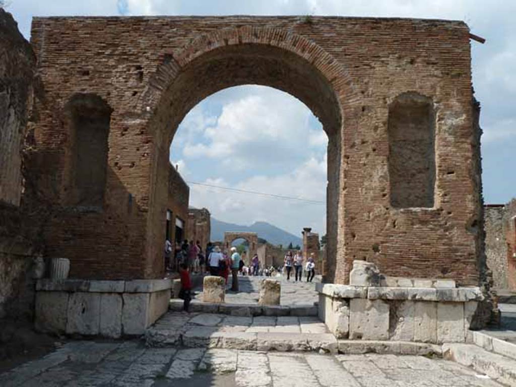 Arch at North East End of the Forum. May 2010. South side, looking north. This arch would have been faced with marble. It has two niches on this side that once held statues of Nero and Drusus.