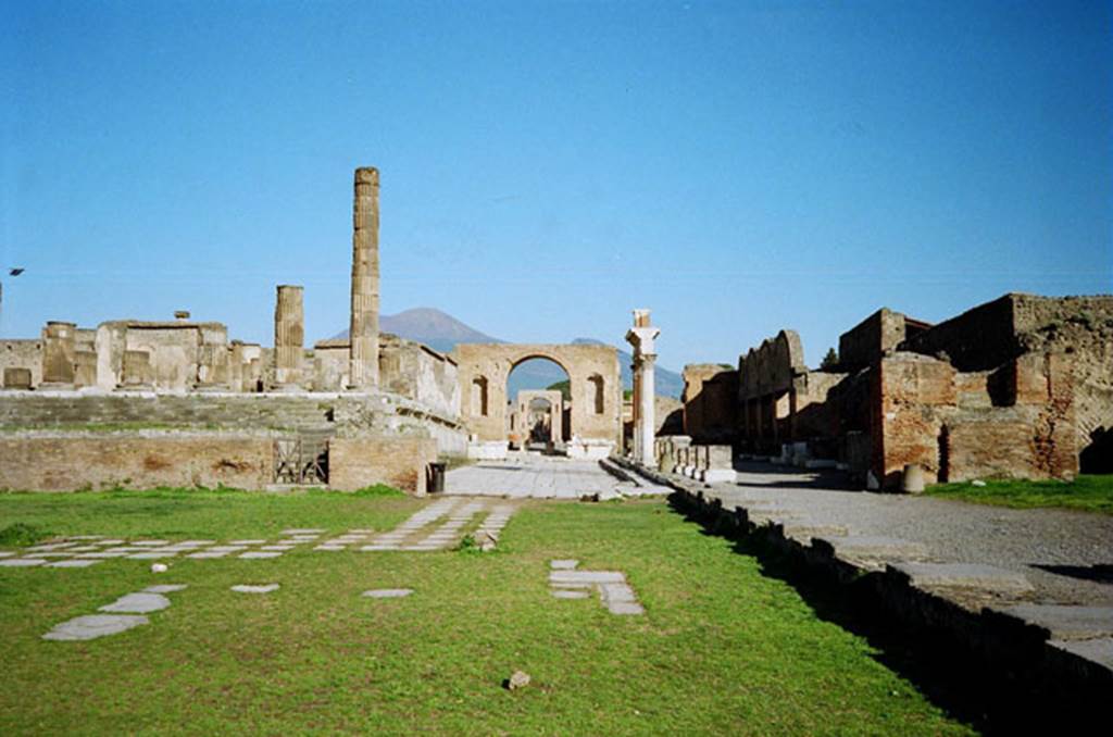 Arch at North East End of the Forum. March 2010. Paved area in front of the arch and along the side of the Temple of Jupiter. Photo courtesy of Rick Bauer.