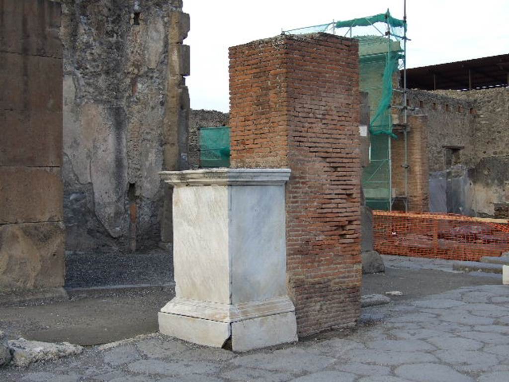 Arch of Marcus Holconius Rufus. December 2006. North west pillar with marble statue base. The brick pillar was one of the four pillars supporting the arch over Via dell Abbondanza. The base when excavated in 1853 had a statue of Marcus Holconius Rufus. The statue is now in Naples Archaeological Museum.  