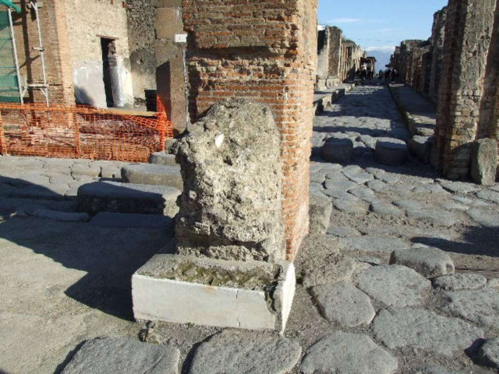 Arch of Marcus Holconius Rufus. December 2006. North-east pillar with remains of another statue base. Looking east along Via dellAbbondanza.